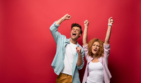 Excited man and women with their arms up